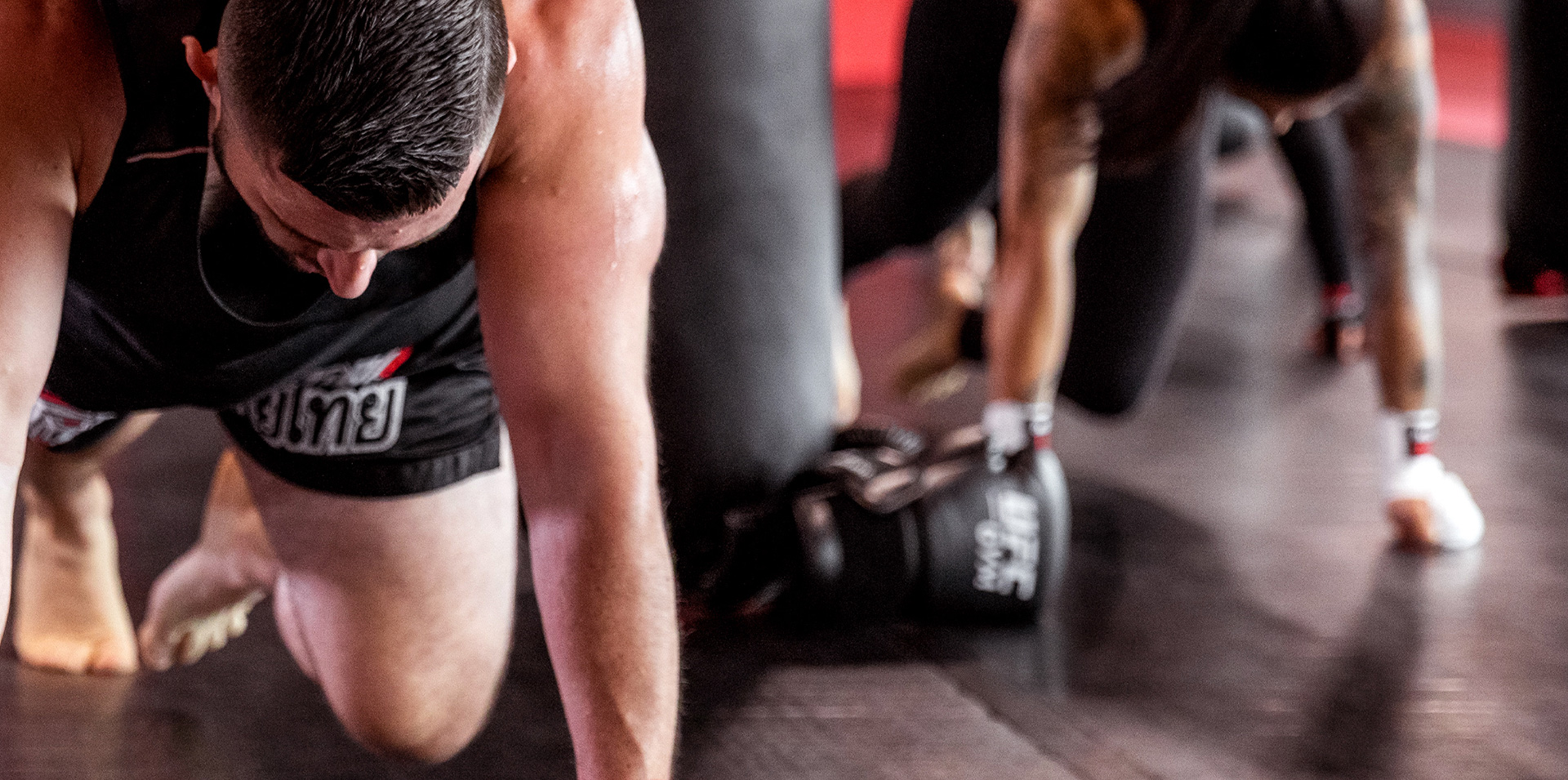 Member kicking sandbag in kickboxing class
